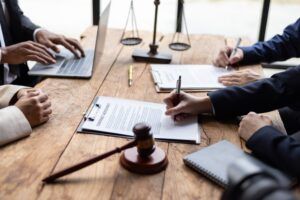 People reviewing paperwork on opposite sides of a table. Learn about whether Section 1782 applies to private international arbitration.